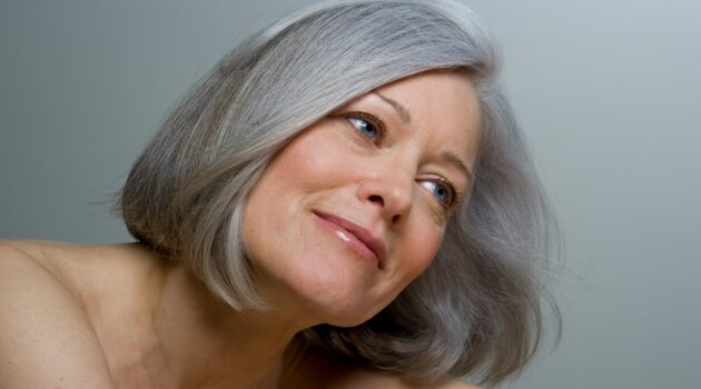 Plano aproximado de uma mulher com um bob grisalho liso e maquilhagem natural
