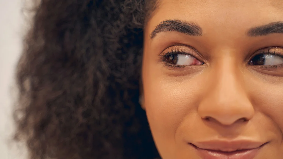 Grande plano dos olhos de uma mulher sorridente, com as sobrancelhas arranjadas e bem definidas