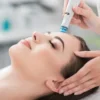 Grande plano de uma mulher relaxada de olhos fechados durante um tratamento HydraFacial num salão tranquilo